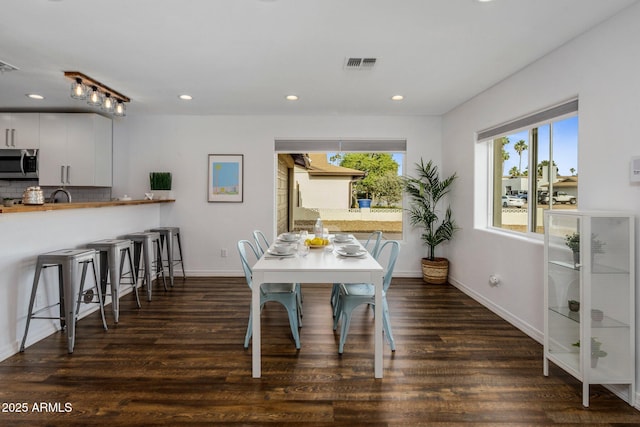 dining room featuring dark wood-type flooring, recessed lighting, visible vents, and baseboards