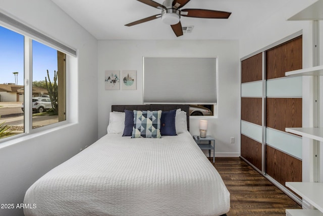 bedroom with ceiling fan, dark wood-style flooring, a closet, and visible vents