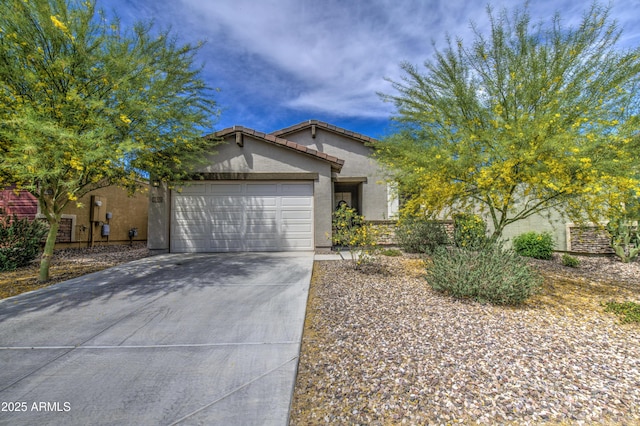 view of front of property with an attached garage, a tiled roof, concrete driveway, and stucco siding