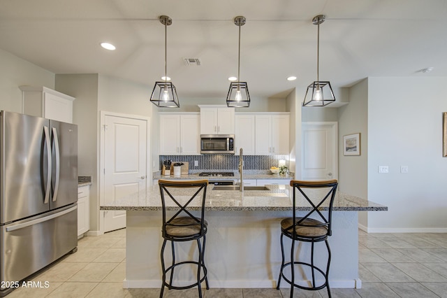 kitchen featuring appliances with stainless steel finishes, light tile patterned floors, backsplash, and visible vents