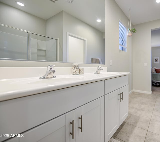 ensuite bathroom with a sink, recessed lighting, double vanity, tile patterned flooring, and a shower with shower door