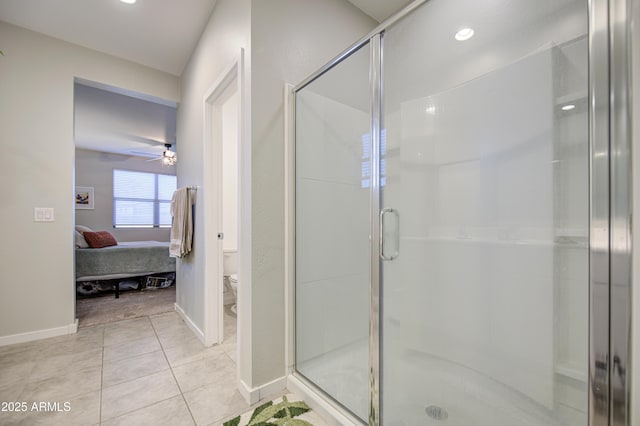 ensuite bathroom featuring a shower stall, tile patterned floors, baseboards, and toilet