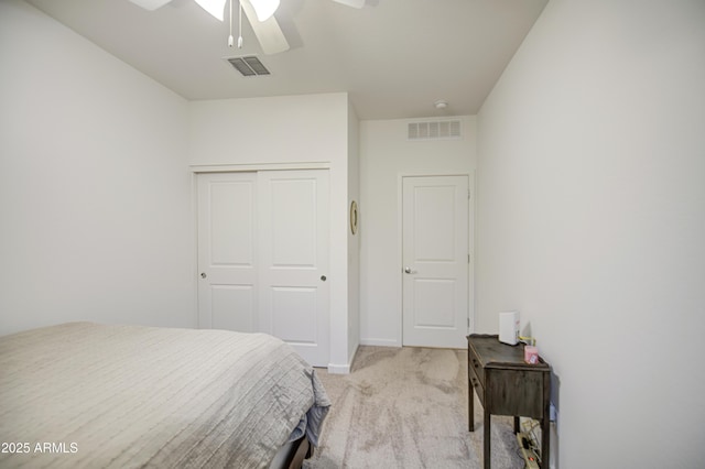 bedroom featuring a closet, light colored carpet, baseboards, and visible vents