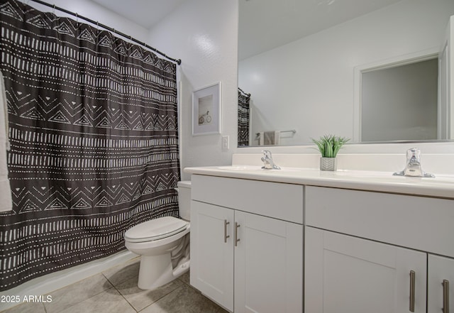 bathroom with a sink, toilet, double vanity, and tile patterned flooring