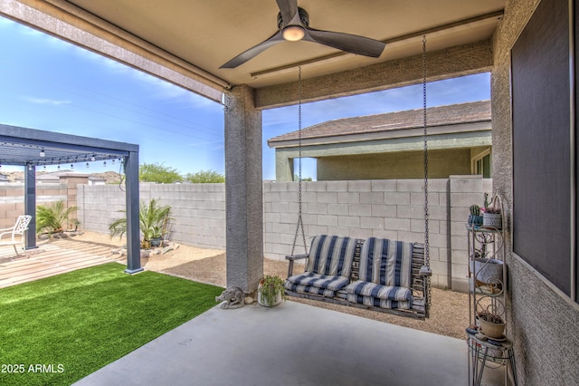 view of patio / terrace with fence and a ceiling fan
