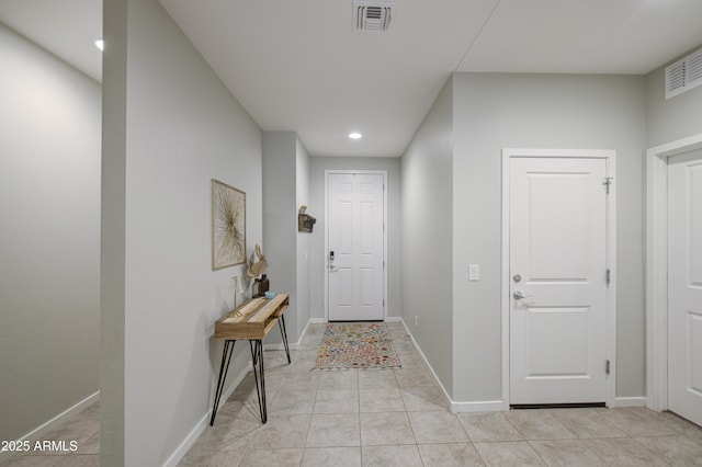 hallway featuring recessed lighting, light tile patterned floors, visible vents, and baseboards