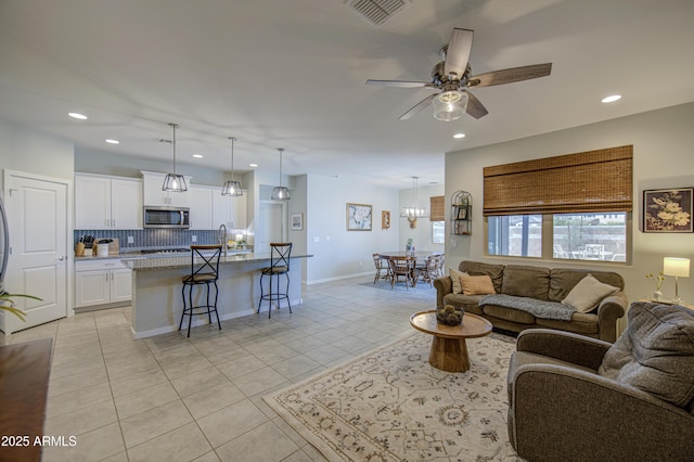 living area with a ceiling fan, visible vents, recessed lighting, light tile patterned flooring, and baseboards