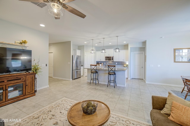 living room featuring a ceiling fan, visible vents, recessed lighting, light tile patterned flooring, and baseboards