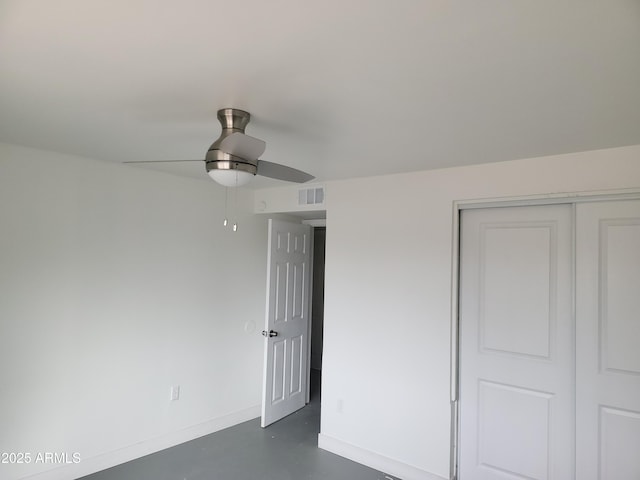 unfurnished bedroom with ceiling fan, concrete floors, visible vents, baseboards, and a closet