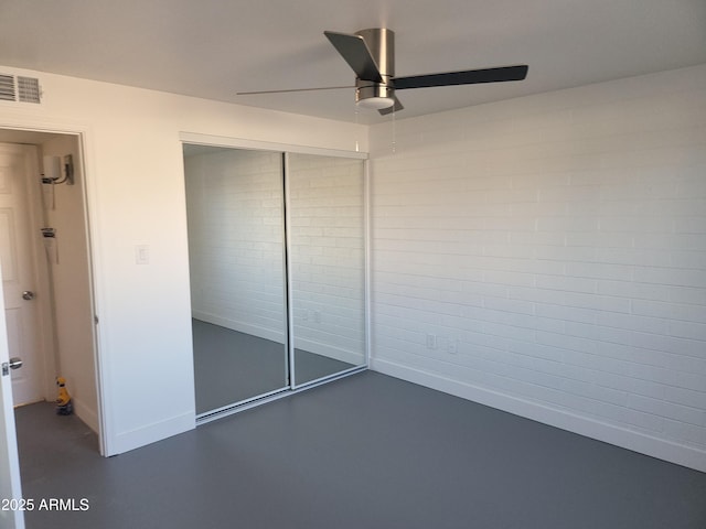 unfurnished bedroom with concrete floors, visible vents, baseboards, a ceiling fan, and a closet