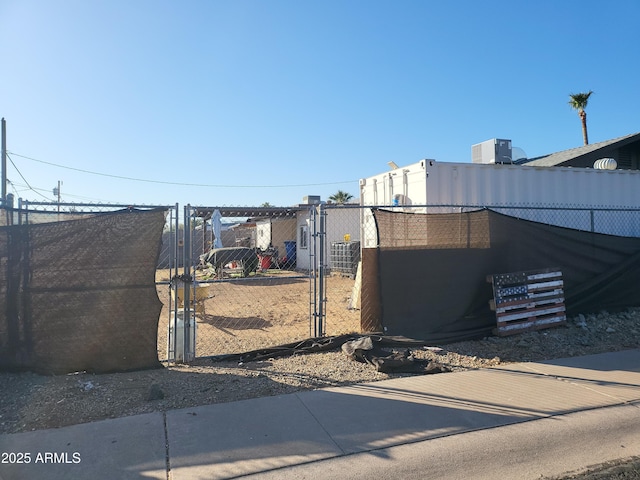 view of gate with fence and central AC unit