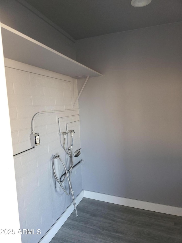 laundry area featuring laundry area, dark wood-style floors, baseboards, and washer hookup