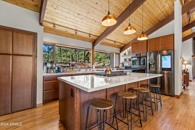 kitchen featuring light wood-type flooring, stainless steel appliances, decorative light fixtures, and wooden ceiling