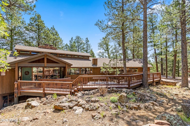 rear view of property featuring a wooden deck