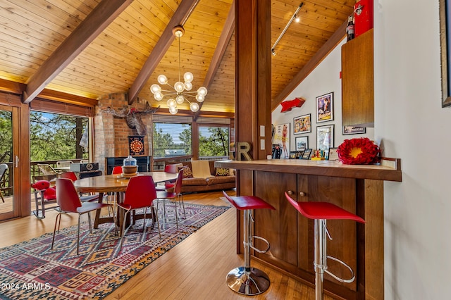 dining room featuring a wealth of natural light, beamed ceiling, wooden ceiling, and light hardwood / wood-style flooring