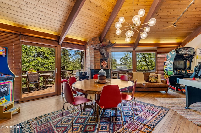 dining space with light hardwood / wood-style floors, vaulted ceiling with beams, and a healthy amount of sunlight