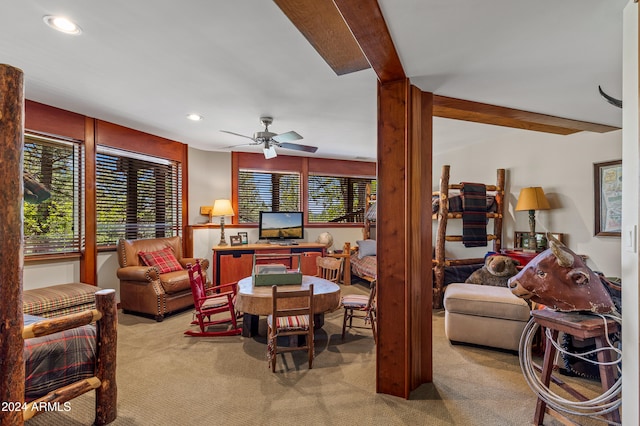 carpeted living room featuring ceiling fan and beamed ceiling