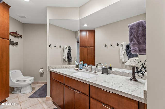 bathroom with tile patterned flooring, vanity, and toilet