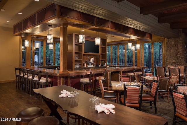 bar featuring hardwood / wood-style floors, beamed ceiling, and decorative light fixtures