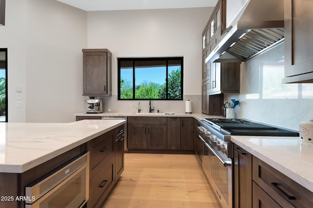 39419 N 7th Ave, Phoenix, AZ 85086 - kitchen with stainless steel appliances, range hood, a sink, light wood-style floors, and light stone counters