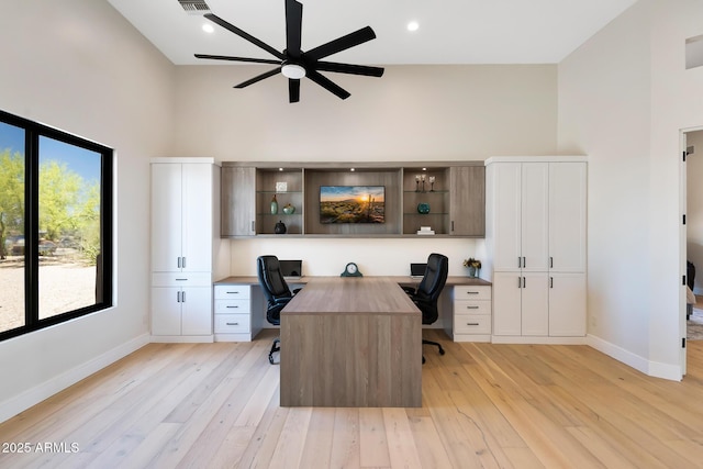 39419 N 7th Ave, Phoenix, AZ 85086 - home office with built in desk, a ceiling fan, baseboards, a towering ceiling, and light wood-type flooring