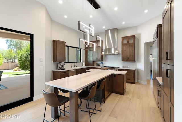 39419 N 7th Ave, Phoenix, AZ 85086 - kitchen with wall chimney range hood, dishwasher, a center island, light wood-type flooring, and a kitchen breakfast bar