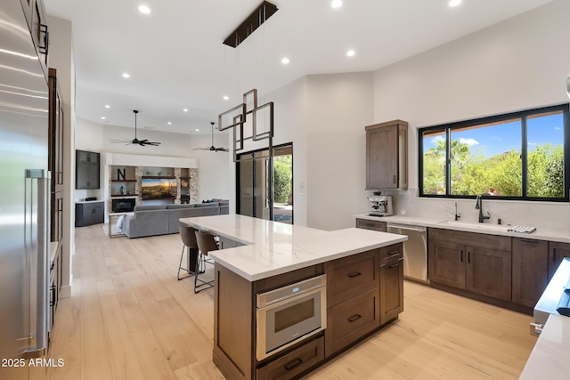 39419 N 7th Ave, Phoenix, AZ 85086 - kitchen with stainless steel appliances, a sink, a kitchen island, light wood-style flooring, and recessed lighting