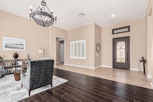 foyer entrance with hardwood / wood-style flooring and an inviting chandelier