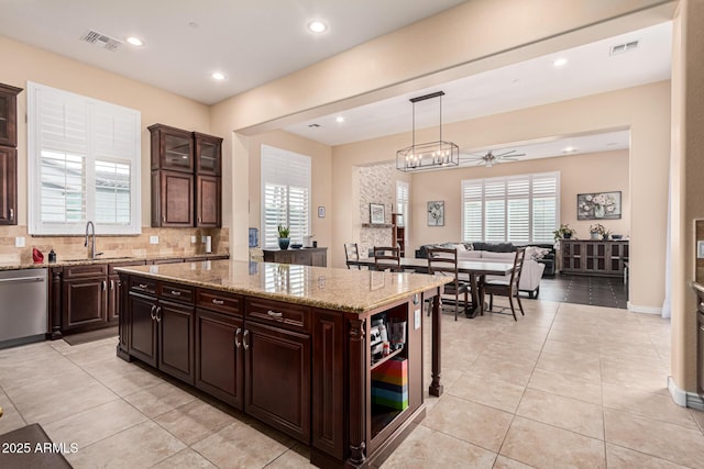 kitchen featuring a center island, dark brown cabinets, dishwasher, and hanging light fixtures