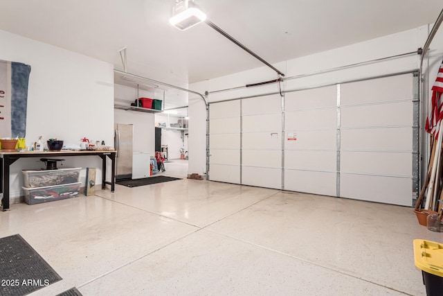 garage featuring a garage door opener and stainless steel fridge