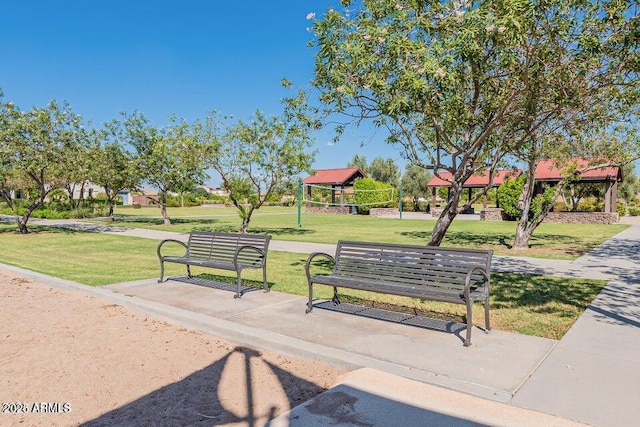 view of home's community with volleyball court and a lawn