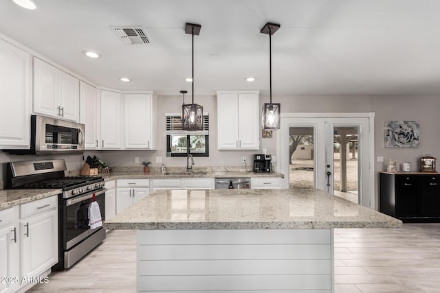 kitchen featuring light stone counters, appliances with stainless steel finishes, visible vents, white cabinets, and recessed lighting