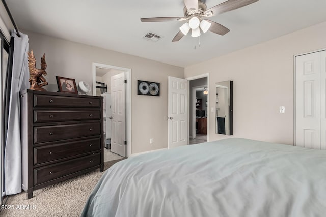 bedroom featuring ensuite bathroom, visible vents, baseboards, a ceiling fan, and light colored carpet