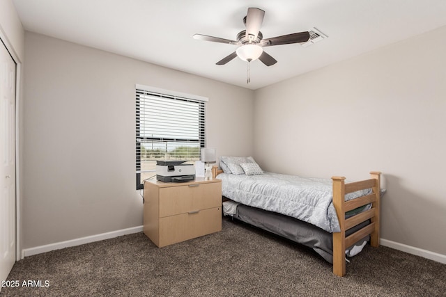 bedroom with baseboards, visible vents, dark carpet, and a closet