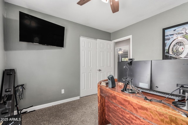 carpeted office space featuring baseboards and a ceiling fan