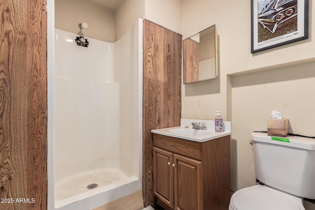 full bathroom featuring toilet, vanity, and a shower stall