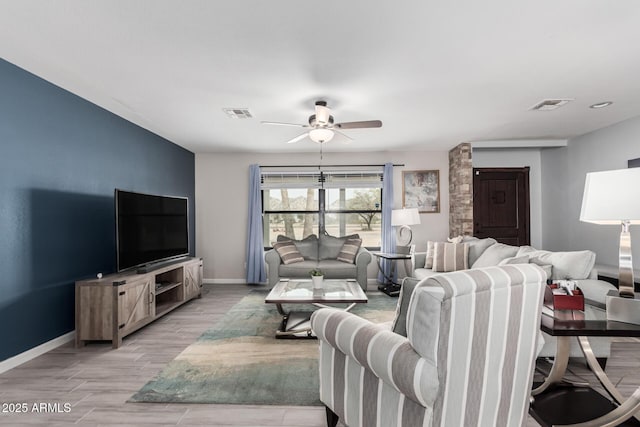 living room featuring a ceiling fan, baseboards, light wood finished floors, and visible vents