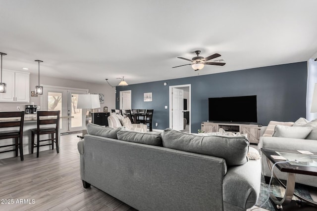 living room featuring light wood finished floors, french doors, and a ceiling fan