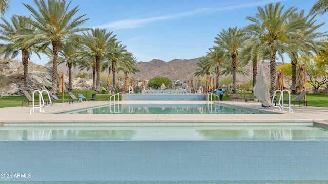 pool with a lawn, a mountain view, and a patio