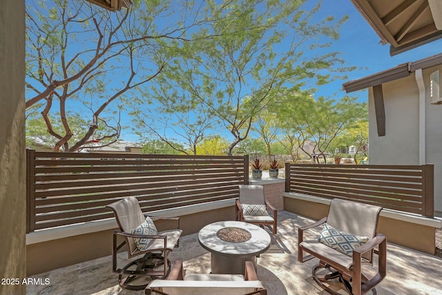 view of patio with fence and a fire pit