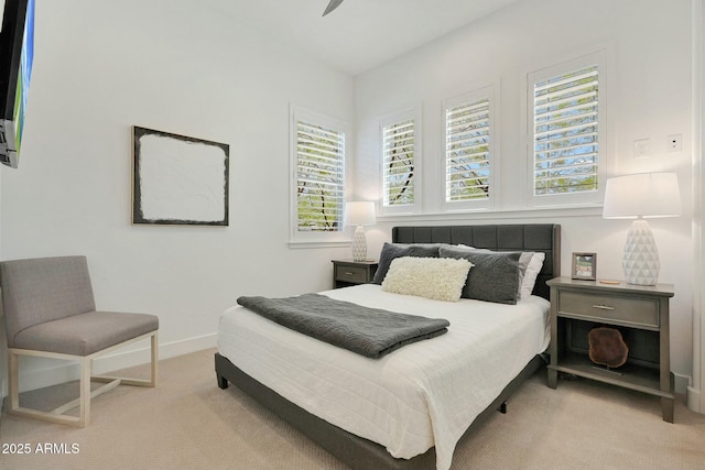 bedroom featuring baseboards and light colored carpet
