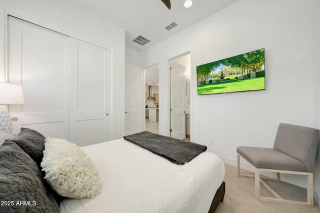 carpeted bedroom featuring visible vents and a closet