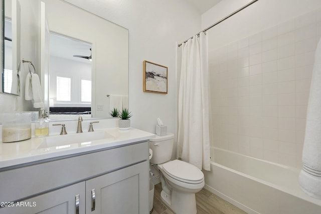 bathroom featuring shower / bath combination with curtain, toilet, vanity, and wood finished floors