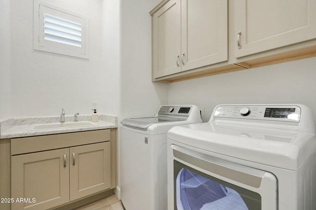 laundry area featuring separate washer and dryer, a sink, and cabinet space