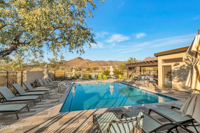 community pool featuring a patio area, fence, and a mountain view