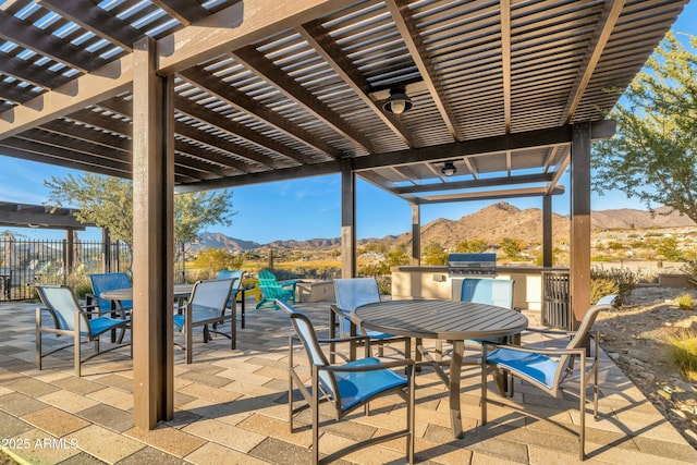 view of patio / terrace with a pergola, outdoor dining area, exterior kitchen, and a mountain view