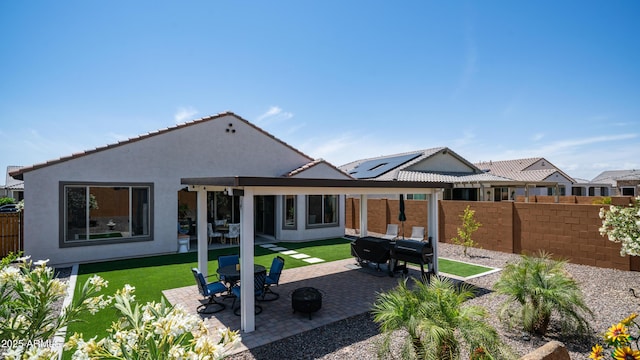 27636 W Runion Dr, Buckeye, AZ 85396 - rear view of property featuring a patio, stucco siding, a fire pit, and a tile roof