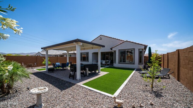 27636 W Runion Dr, Buckeye, AZ 85396 - back of property with a fenced backyard, stucco siding, and a patio area