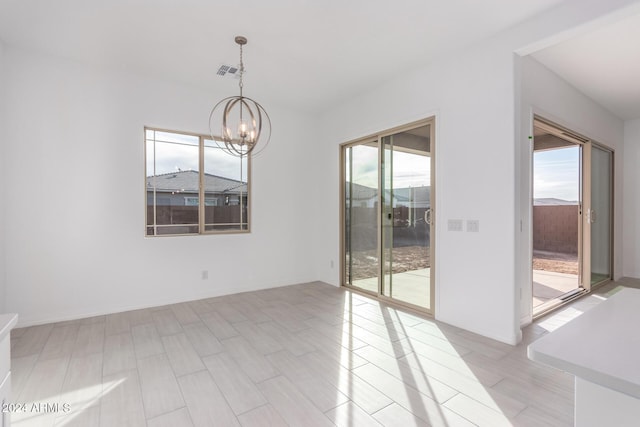 empty room with a healthy amount of sunlight and an inviting chandelier