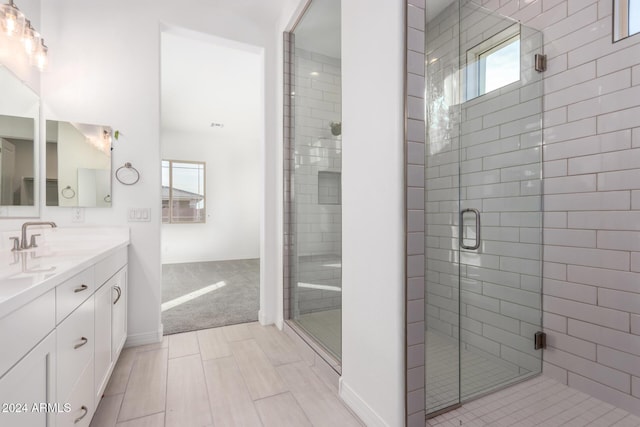 bathroom with a shower with door and vanity